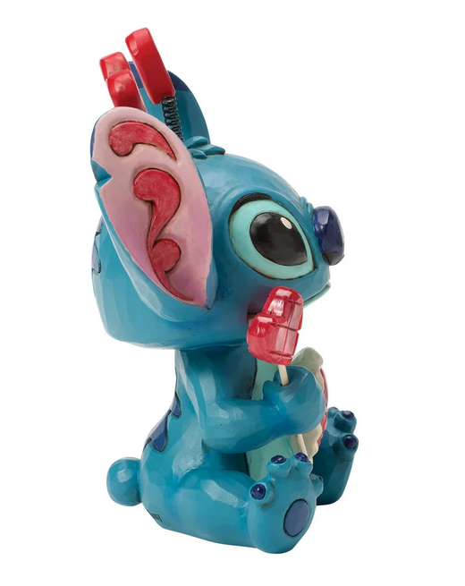 Side of Stitch figurine holding a heart lollipop on a white background