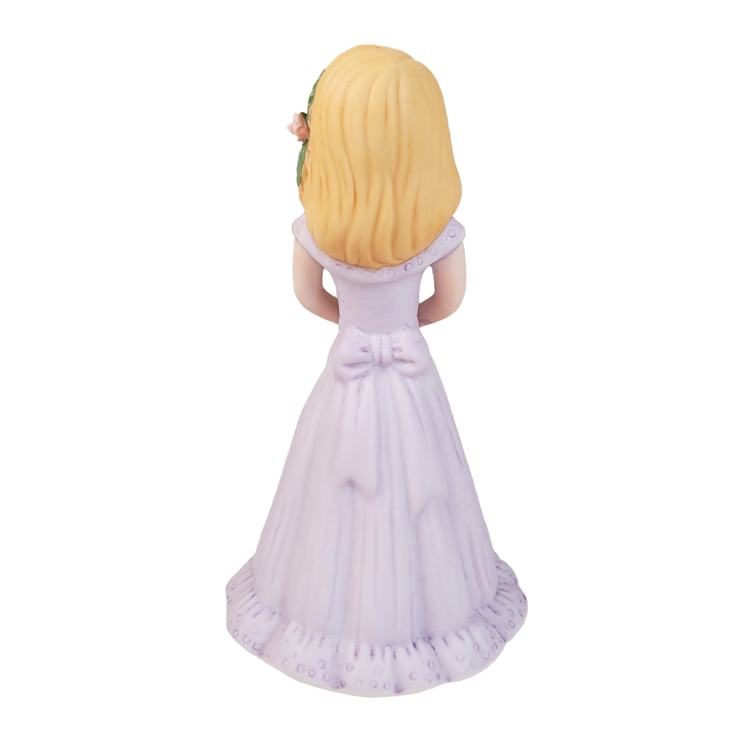 back of figurine of a girl in a purple dress on a white background