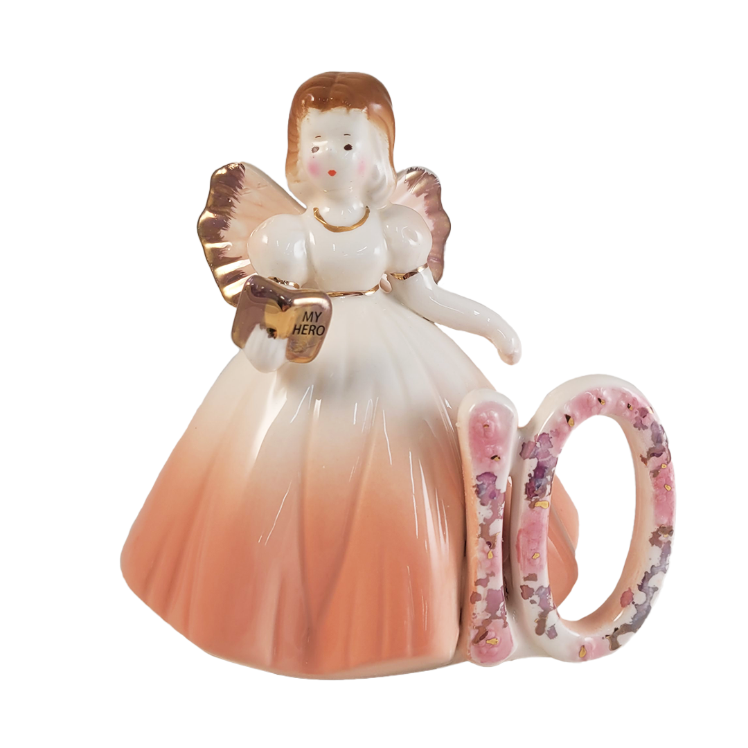 Front of angel figurine with a book wearing a peach dress with a number 10 on a white background
