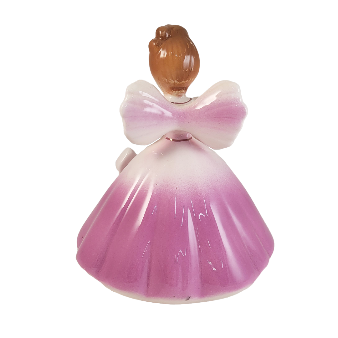 back of angel figurine wearing a purple dress on a white background