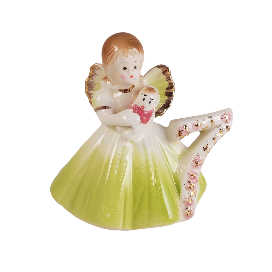 Decorative figurine of an angel holding a baby doll with a number 7 on a white background