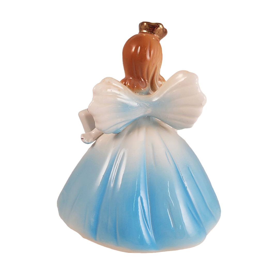 Back of angel figurine in a blue dress on a white background