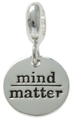 A silver circle charm with the words 'mind' and 'matter' written on it, forming the phrase 'Mind over Matter'.