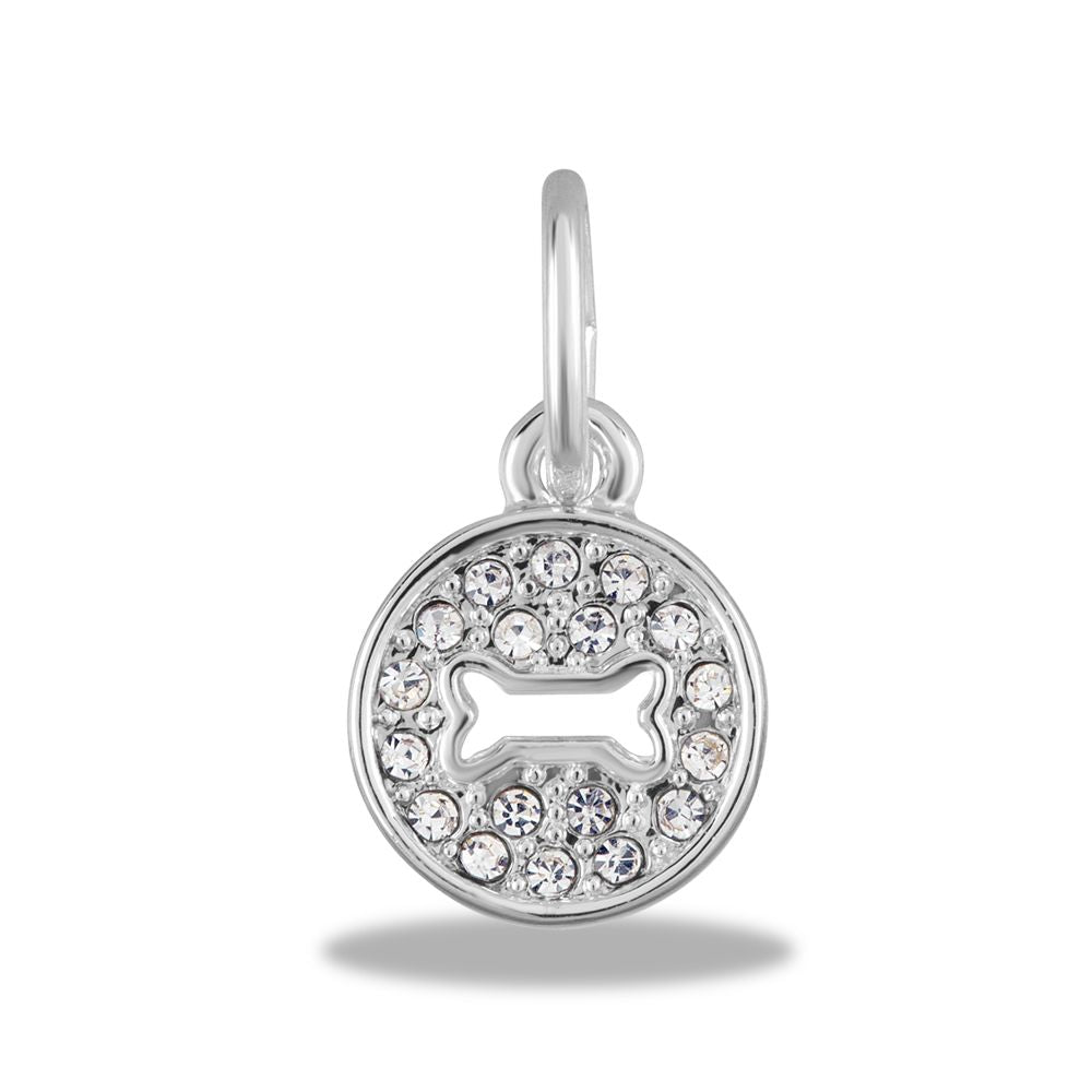 A silver circle charm with crystals surrounding a dog bone shape cut out in the center