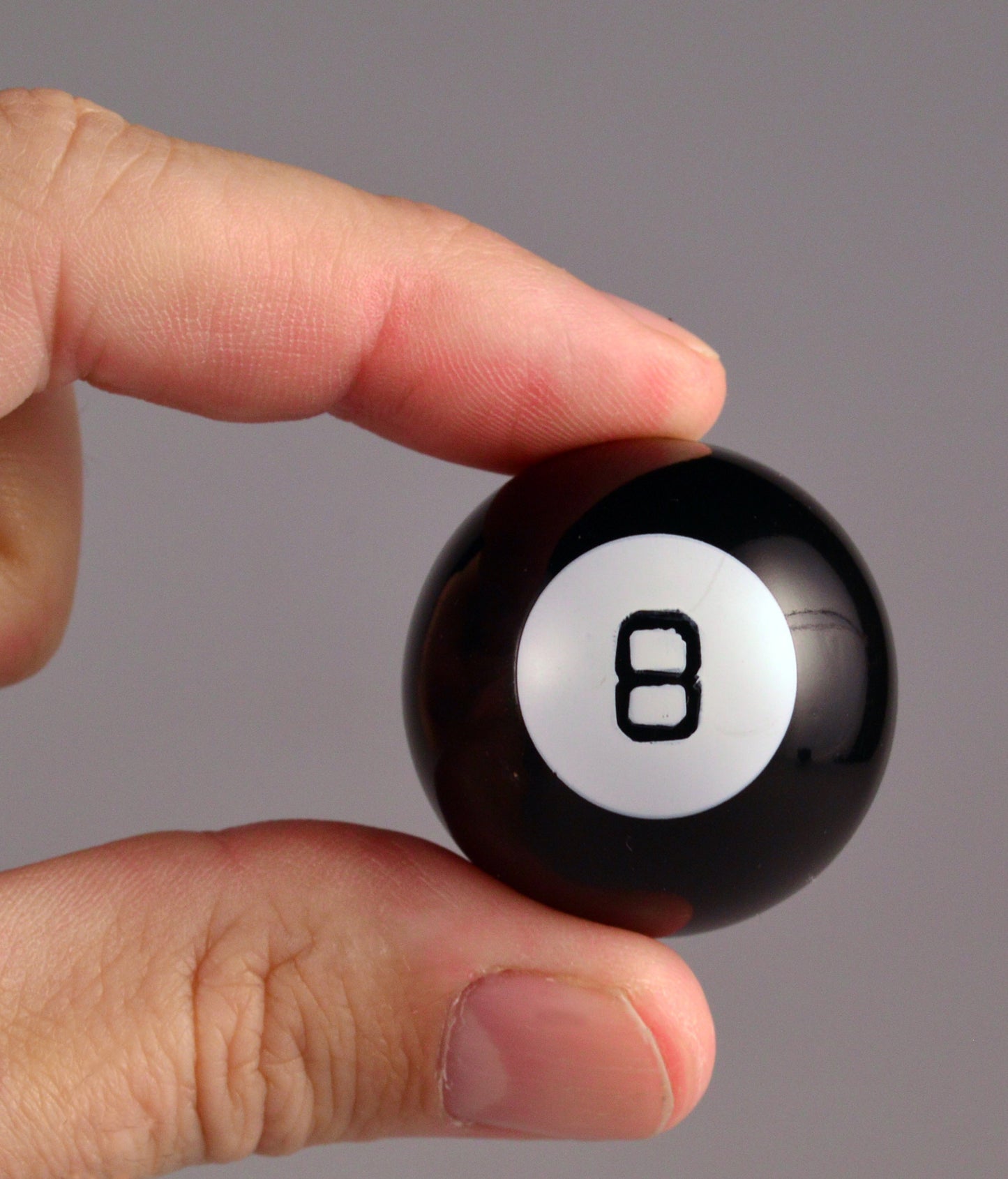 fingers holding magic eight ball