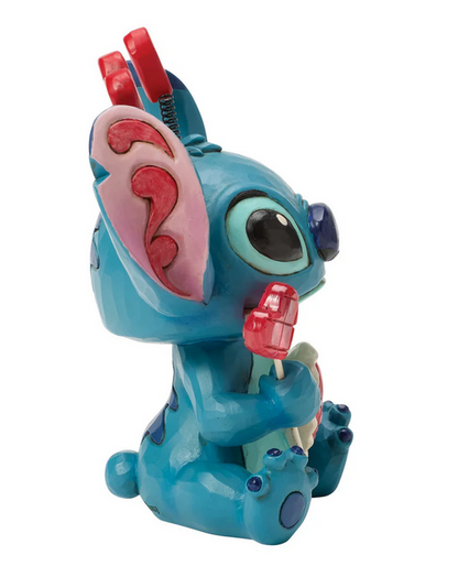 Side of Stitch figurine holding a heart lollipop on a white background