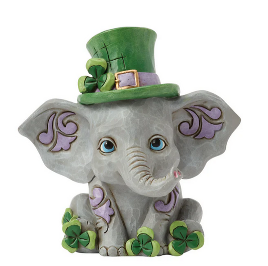 Elephant figurine wearing a green top hat with shamrock decorations on a white background