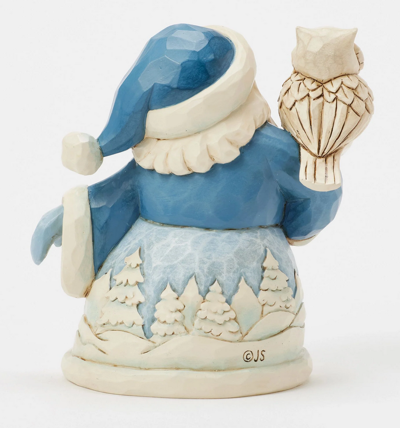 Back of decorative figurine of a Santa Claus with an owl on his shoulder, with a snowy landscape robe.