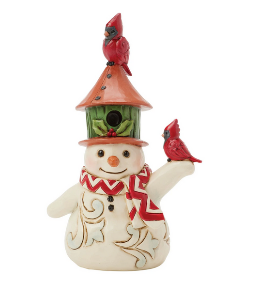 Front of snowman figurine with a birdhouse on its head and two red birds, against a white background