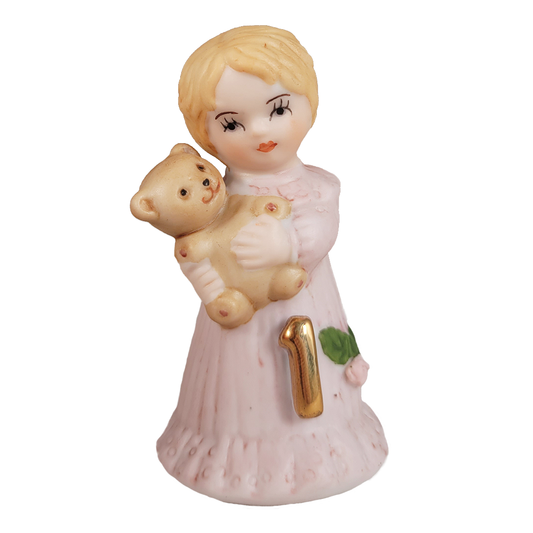 Figurine of a girl holding a teddy bear on a white background