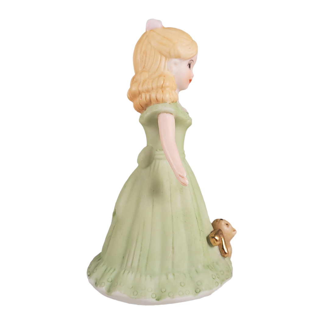 Side of figurine of a woman in a green dress on a white background