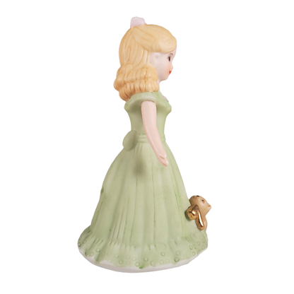 Side of figurine of a woman in a green dress on a white background