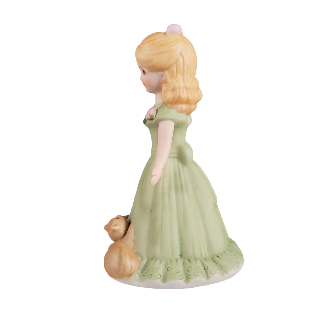 Side figurine of a woman in a green dress with a cat on a white background