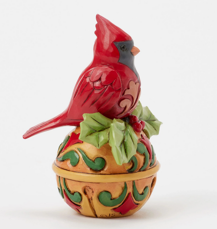Side view of decorative cardinal figurine on bell a white background