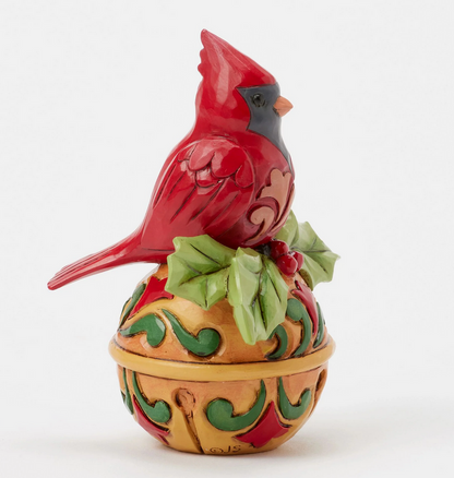 Side view of decorative cardinal figurine on bell a white background