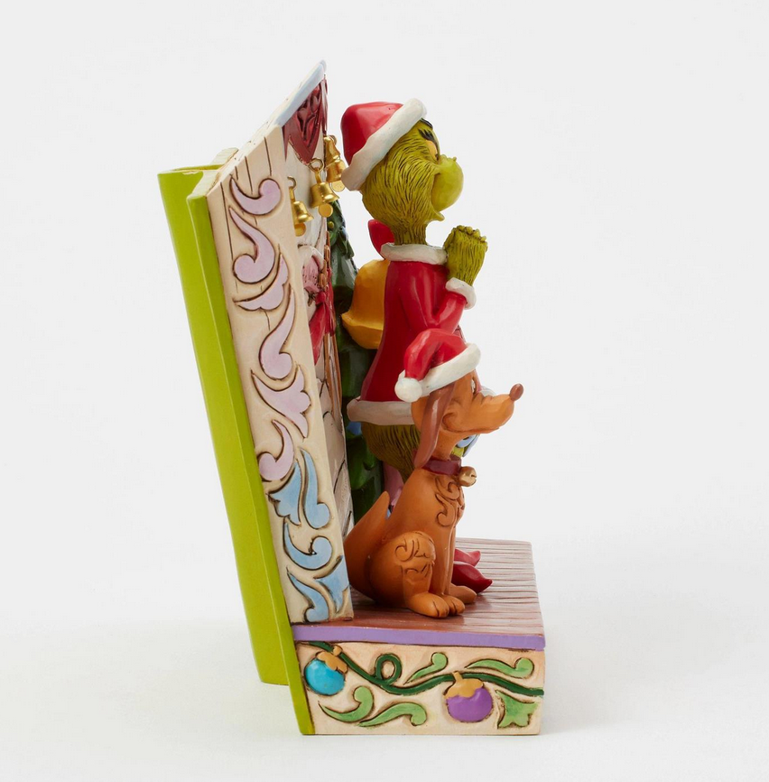 Decorative figurine of a dog and a cat in Santa hats with a book on a white background