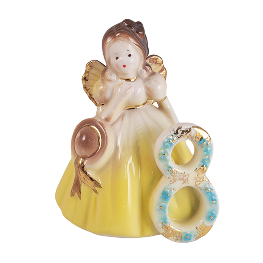 Front of decorative angel figurine in yellow dress with number 8 on a white background