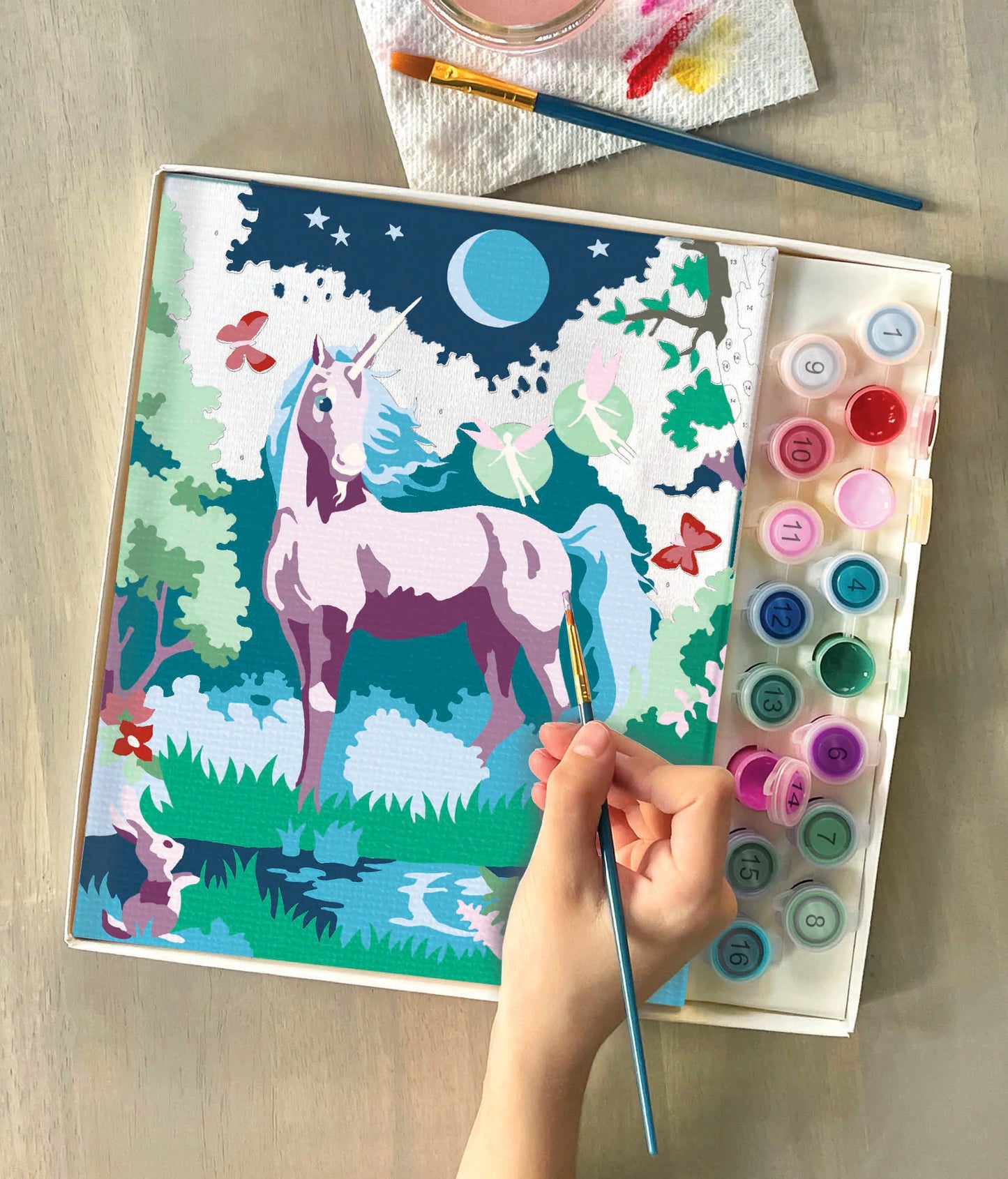 person painting unicorn canvas
