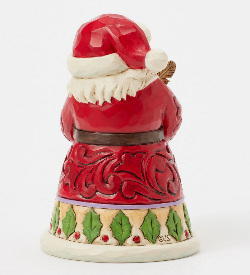 Back of Santa Claus figurine holding a feather and quill on a white background