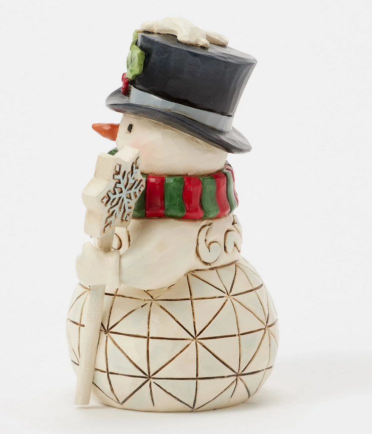 Side of decorative snowman figurine with a top hat, scarf, and snowflake wand on a white background